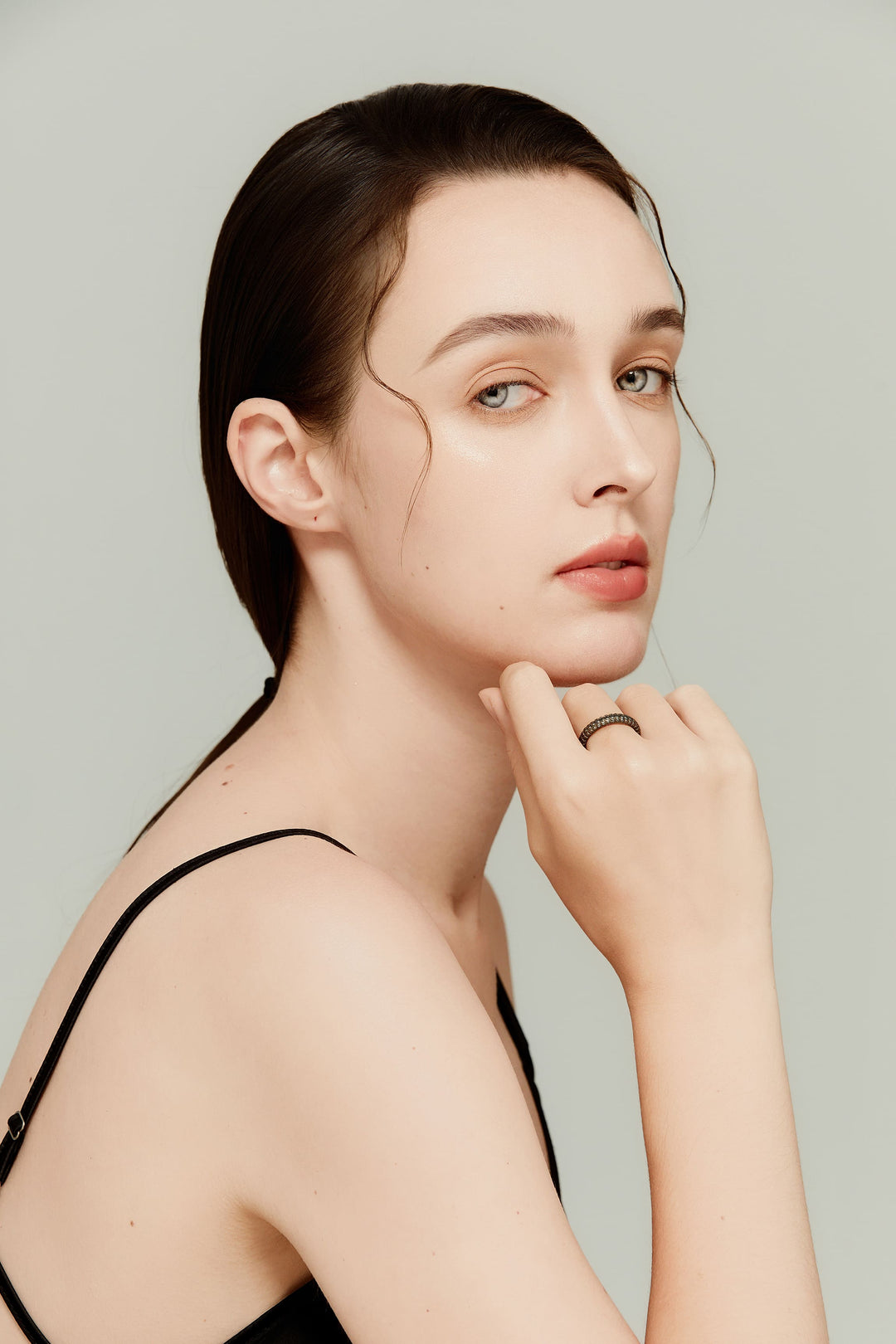 Model wearing 14K black gold ring with three rows of black diamonds; understated luxury.