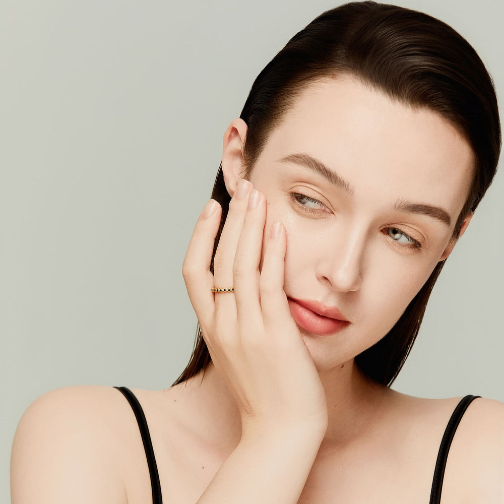 Close-up of model hand wearing full eternity black diamond ring; refined and sophisticated style.