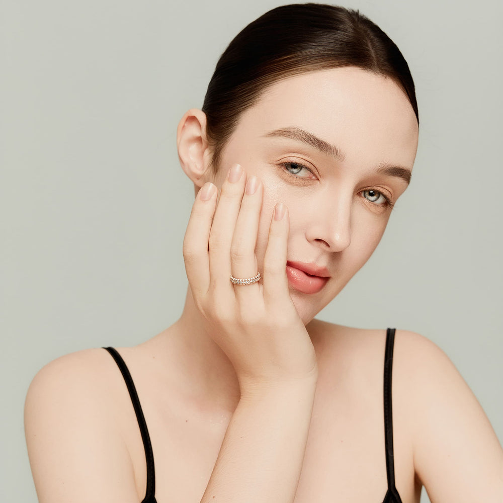 Close-up of female model wearing a 14K rose gold lab-grown diamond eternity band ring, showcasing elegance and unisex styling.