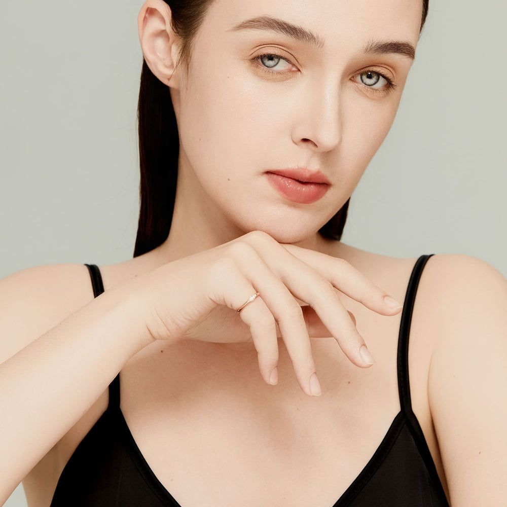 Model wearing 14k rose gold marquise solitaire ring; modern city-chic styling
