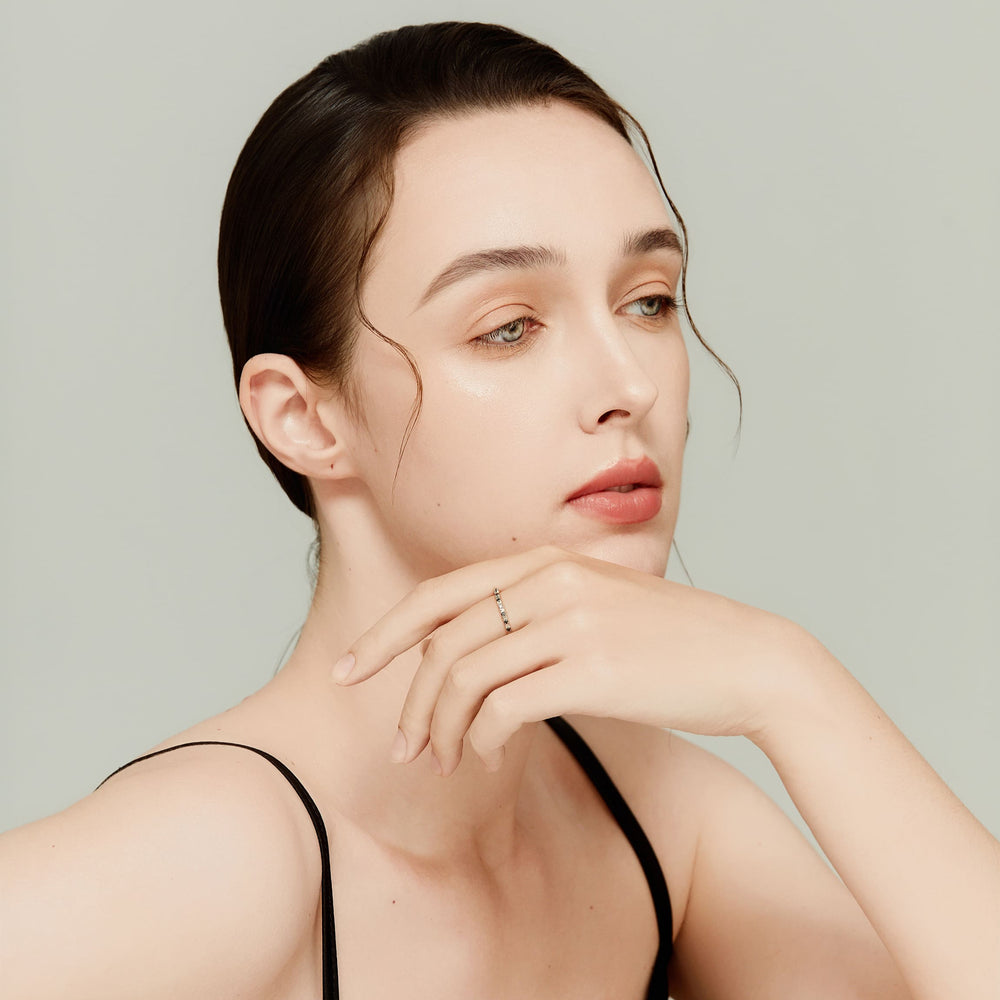 Model wearing 14K white gold eternity ring with alternating black and white diamonds, styled with minimal makeup and black top.