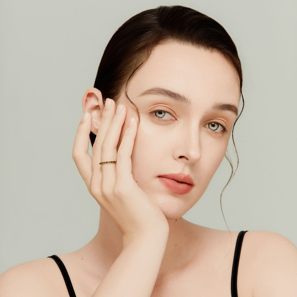 Model wearing 14K yellow gold black diamond eternity ring; unisex, modern and edgy.