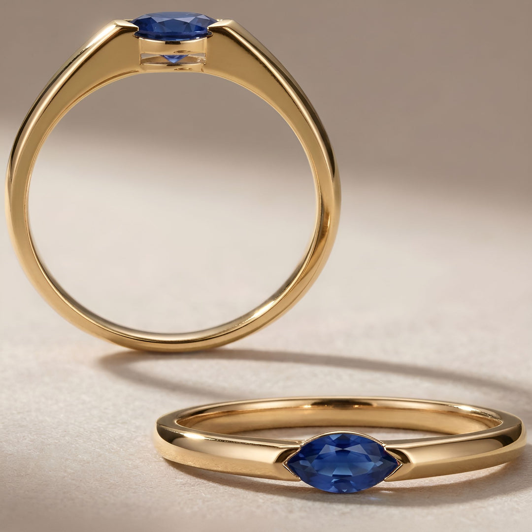 Gold ring with blue gemstone on a beige background